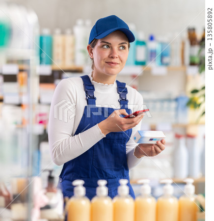 Young woman worker scanning qr code of ointment Young woman worker scanning qr code of ointment 135805892