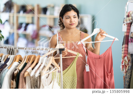 Girl at trading floor pick out and buying sundress or tank top 135805998