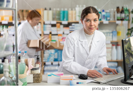 Female pharmacist working at computer in pharmacy 135806267