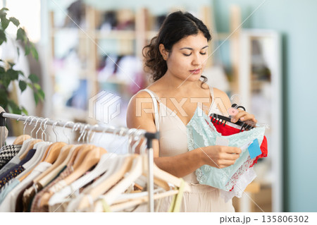 Young woman chooses panties in clothing store 135806302