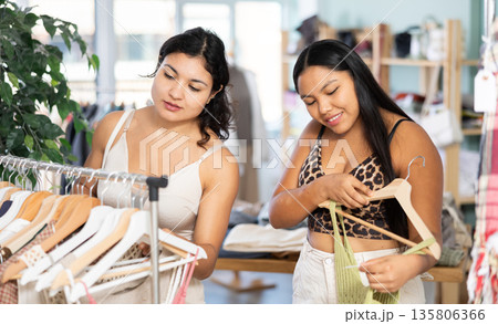 Two young women choosing dresses and tops in store 135806366