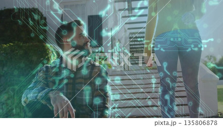 Sitting man on porch steps, looking at woman in yellow sweater, with circuit board overlay 135806878
