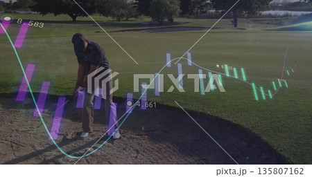 Swinging middle aged male golfer hitting golf ball from sand bunker, with translucent data overlays 135807162