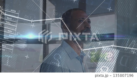 Analyzing executive in blue shirt interpreting interface in office, with line charts and tables 135807196