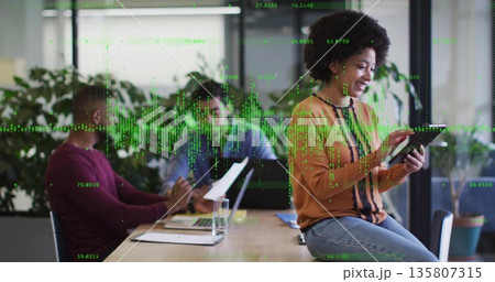 Using tablet, Black female worker consulting data in meeting room, with digital data overlay 135807315