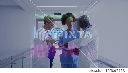 Doctors and nurse analyzing holographic vitals display in hospital corridor, with purple clipboard 135807458
