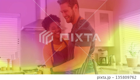 Stirring romantic couple cooking eggs in frying pan in home kitchen, with striped aprons 135809762