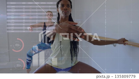 Performing barre squat fitness partners in bright studio room, with wooden barre and data overlays Performing barre squat fitness partners in bright studio room, with wooden barre and data overlays 135809779