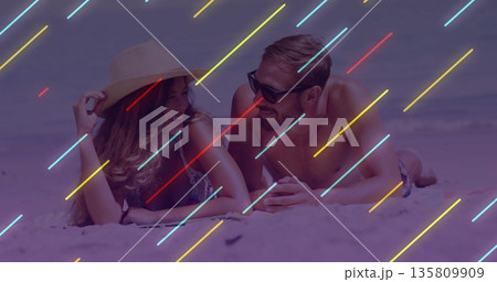 Lying couple wearing straw hat, dark sunglasses, bikini, trunks on sandy beach with neon streaks Lying couple wearing straw hat, dark sunglasses, bikini, trunks on sandy beach with neon streaks 135809909