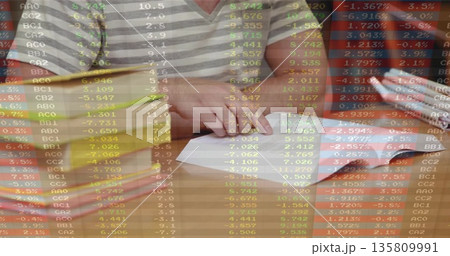 Two friends folding white paper airplane at polished wooden table, with ruler and open magazine Two friends folding white paper airplane at polished wooden table, with ruler and open magazine 135809991