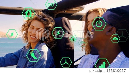 Driving three friends in convertible along coastal road, with green hexagon energy icons overlaying 135810027