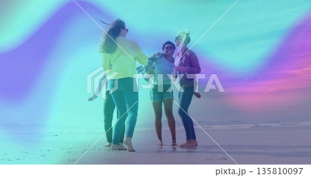 Jumping four friends dancing in shallow beach water, with jeans, denim shorts and light jackets 135810097