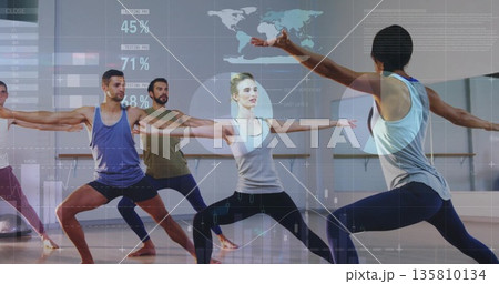 Practicing guided group holding warrior poses in yoga studio, with mats, barre and overlay graphics Practicing guided group holding warrior poses in yoga studio, with mats, barre and overlay graphics 135810134