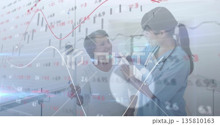 Nurse in scrubs placing stethoscope on patient shoulder at clinic, with cane and market charts 135810163
