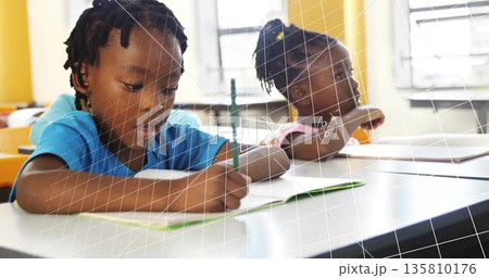 Leaning girl wearing blue shirt writing in notebook with pencil in classroom, copy space Leaning girl wearing blue shirt writing in notebook with pencil in classroom, copy space 135810176