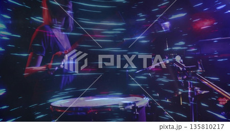 Playing percussionist striking snare drum with drumstick on concert stage, light trails, copy space 135810217