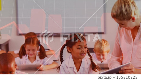 Leaning teacher guiding girl tapping tablet at student desk in classroom, with interactive display Leaning teacher guiding girl tapping tablet at student desk in classroom, with interactive display 135810225