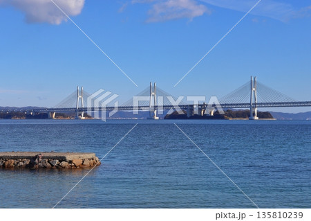 塩飽諸島の本島から眺める瀬戸大橋と岩黒島方面の景色(新在家海岸) 塩飽諸島の本島から眺める瀬戸大橋と岩黒島方面の景色(新在家海岸) 135810239