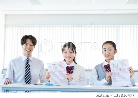 答案用紙を見せる女子中学生 答案用紙を見せる女子中学生 135810477