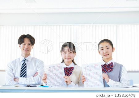 答案用紙を見せる女子中学生 135810479