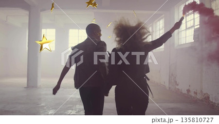 Couple in dark jacket running in industrial loft, with smoke flare and gold stars 135810727