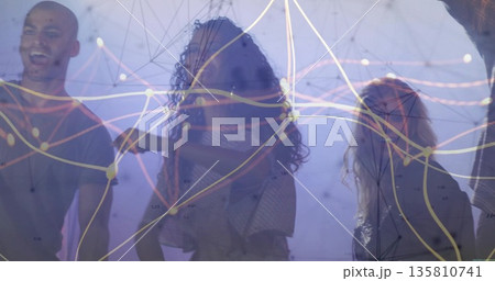Exploring team of four collaborating under digital network projection in dim gallery, haze Exploring team of four collaborating under digital network projection in dim gallery, haze 135810741