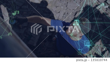 Scaling mid-adult man reaching upward grasping climbing hold at rocky site, with neon-blue overlay Scaling mid-adult man reaching upward grasping climbing hold at rocky site, with neon-blue overlay 135810744