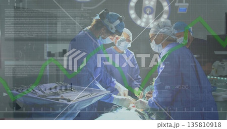 Performing three surgeons making incision in OR, with surgical tray, LED light, monitor screens 135810918