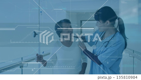 Supporting nurse guiding patient along ward corridor with stethoscope, IV drip stand and handrail 135810984