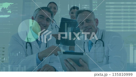 Examining team of doctors analyzing metrics in consultation room, with tablet X-ray film charts 135810999