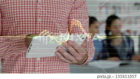 Tapping tablet teacher in checked shirt projecting digital data wave overlay at classroom front 135811057