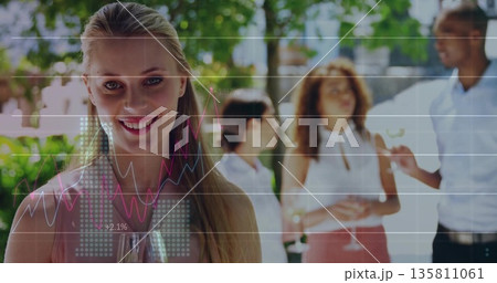 Blonde woman holding wine glass and chatting with colleagues in garden, chart overlay, copy space 135811061