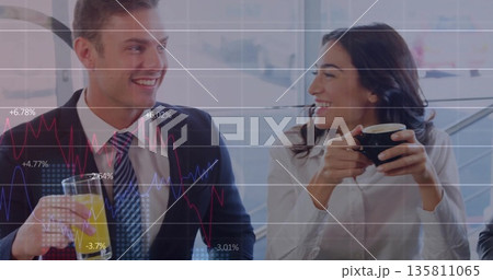 Smiling professionals holding orange juice and black coffee mug in break area with chart overlay 135811065