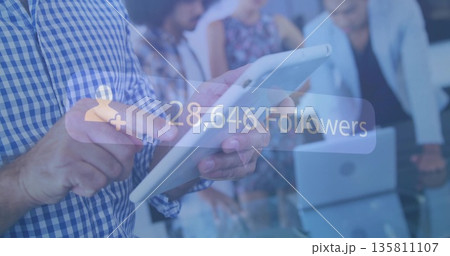 Holding white tablet man in shirt presenting data at conference table, with follower-count overlay 135811107