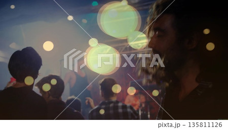 Viewing bearded man watching vocalist in small club with microphone and stage lights, copy space Viewing bearded man watching vocalist in small club with microphone and stage lights, copy space 135811126
