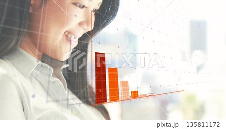 Analyzing Asian professional examining orange and red bar chart grid overlay at office, copy space Analyzing Asian professional examining orange and red bar chart grid overlay at office, copy space 135811172