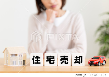 住宅売却のブロックと悩むミドル女性 住宅売却のブロックと悩むミドル女性 135811193