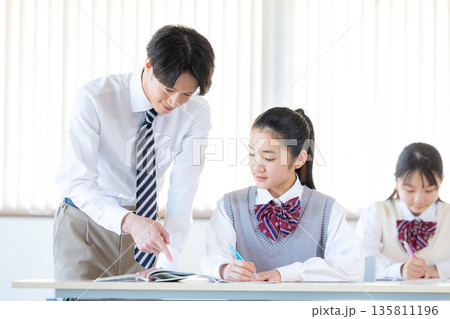 塾で勉強する学生と講師 135811196