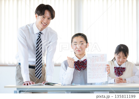 答案用紙を見せる女子中学生 135811199