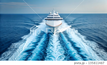 Luxury cruise ship navigating through calm ocean waters with wake trails behind 135811487