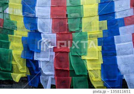 Prayer flags hanging in sacred place in rural Nepal. The prayer flags initiate peace and good tidings, their sacred mantras etched on the wind. Prayer flags hanging in sacred place in rural Nepal. The prayer flags initiate peace and good tidings, their sacred mantras etched on the wind. 135811651