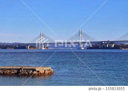 塩飽諸島の本島から眺める瀬戸大橋と鷲羽山方面の景色（新在家海岸） 135813055