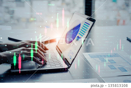 ノートパソコンを使うビジネスパーソンと金融チャートのコンセプト 135813108