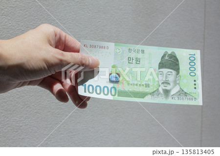 A woman's hand holding ten thousand won 135813405