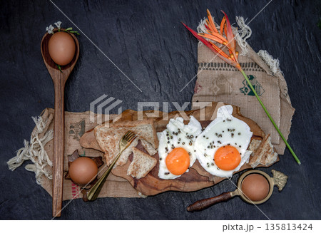 Two fried eggs with toast for healthy breakfast on beautiful wooden background, Nutrition concept. Two fried eggs with toast for healthy breakfast on beautiful wooden background, Nutrition concept. 135813424