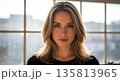 Confident businesswoman standing in modern office with natural light 135813965
