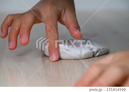 粘土を指で押して遊ぶ子供の手元 135814500