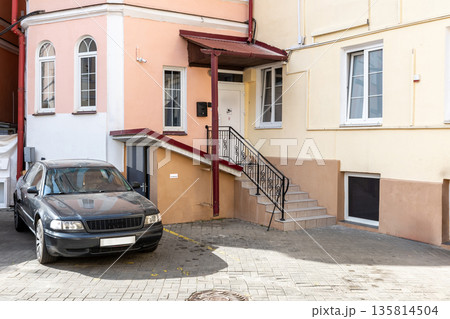 Building entrance with stairs, car parking, and classic architecture 135814504