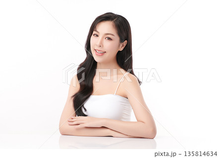 A beautiful young Asian woman with clean, fresh skin against a white background. Skincare, facial treatment, cosmetology, beauty, and spa. An elegant portrait of an Asian woman. 135814634