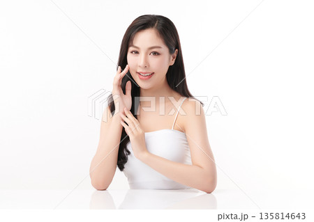 A beautiful young Asian woman with clean, fresh skin against a white background. Skincare, facial treatment, cosmetology, beauty, and spa. An elegant portrait of an Asian woman. 135814643
